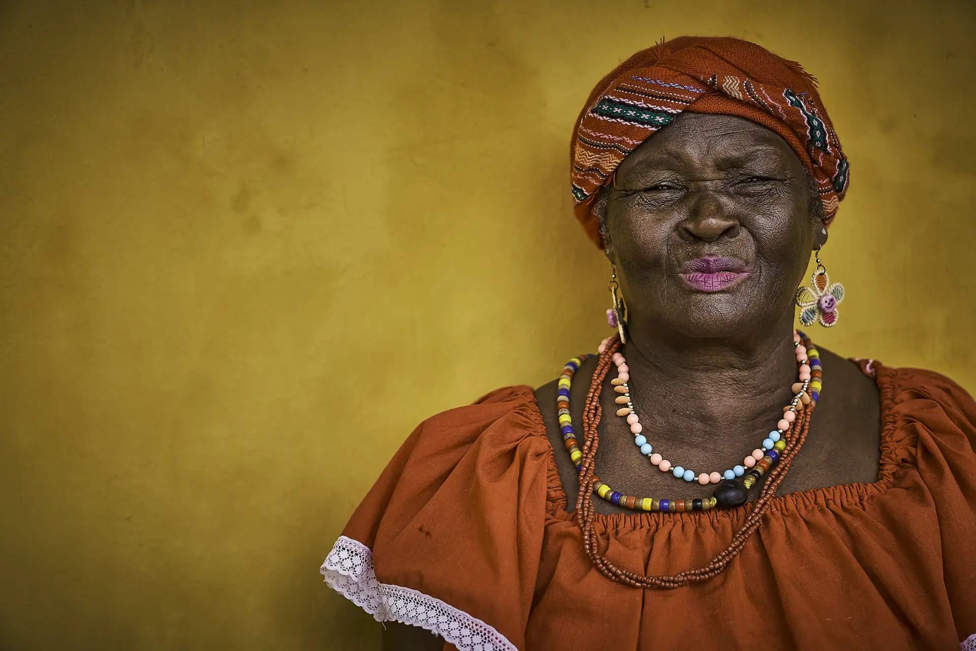 Palenquera frente a un muro ocre