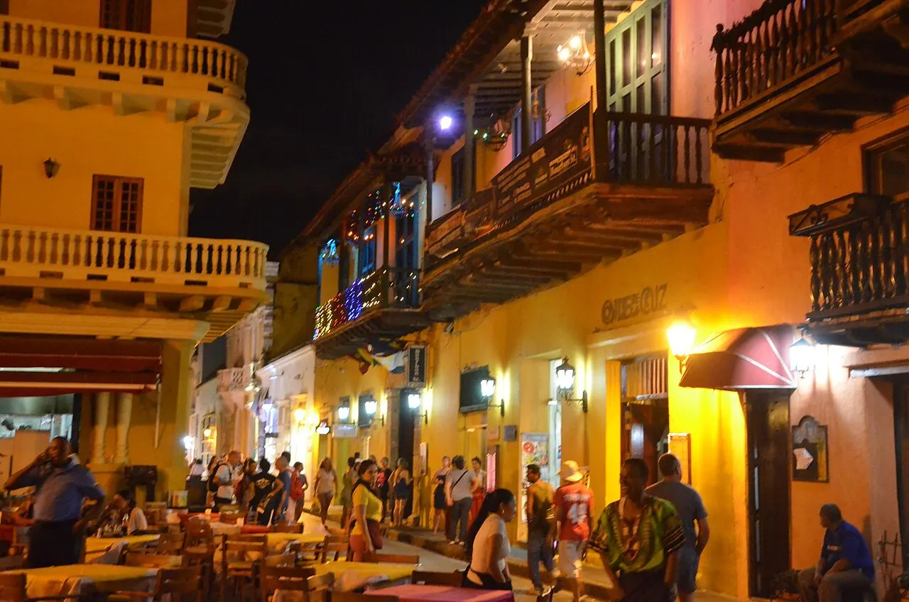 Plaza Santo Domingo de noche, con mesas de restaurante y balcones iluminados